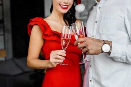 partial view of couple celebrating christmas and clinking by champagne glasses at homeの写真素材