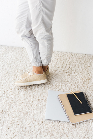 Low section view of casual man and laptop on beige rugの写真素材