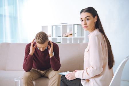 male patient having therapy appointment at psychologist officeの写真素材