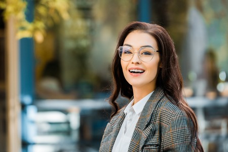 beautiful cheerful girl in stylish jacket and glassesの写真素材