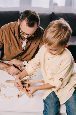 father and little son modeling together at homeの写真素材