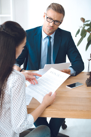 male lawyer looking at client reading contractの写真素材