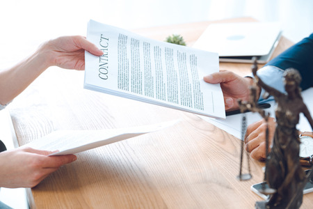 close-up partial view of lawyer and client holding contractの写真素材