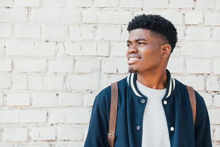 portrait of young african american man in trendy blue bomberの写真素材
