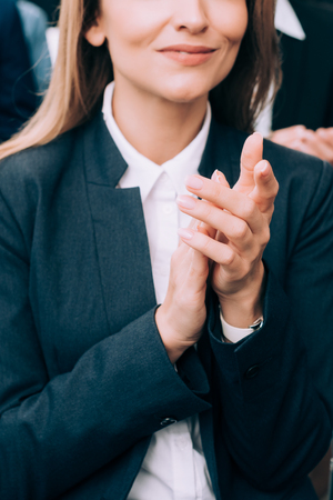 cropped image of businesswoman applauding during seminar in conference hallの写真素材
