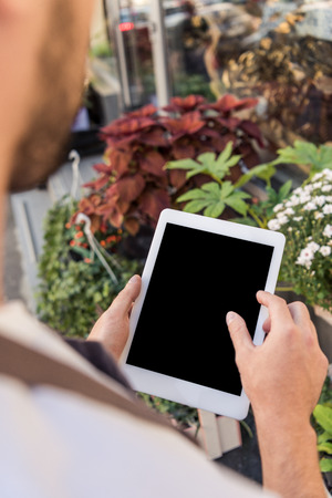 Cropped image of florist using tablet with blank screen near flower shopの写真素材