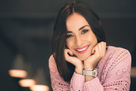 Close up portrait of young beautiful looking at camera in cafeの写真素材