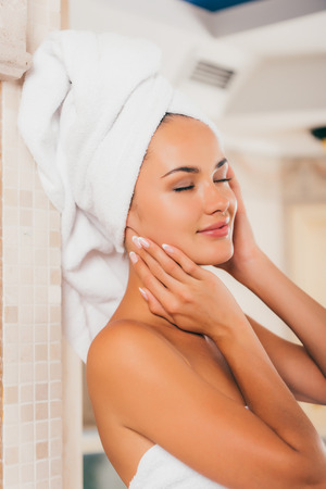 Beautiful woman in white bath robe with perfect clean faceの写真素材