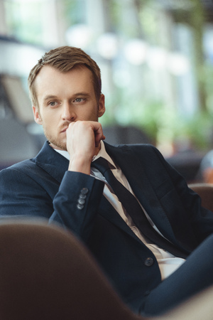 Portrait of thoughtful businessman resting in coffee shopの写真素材