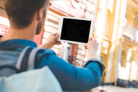 Cropped shot of young man using tablet with blank screen on streetの写真素材