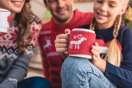 Selective focus of parents and daughter with Christmas cups of cappuccino at homeの写真素材