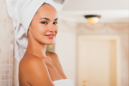 Attractive smiling woman relaxing with towel on headの写真素材