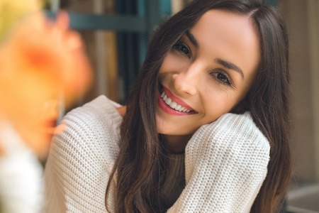 Portrait of happy beautiful woman looking at camera in cafeの写真素材
