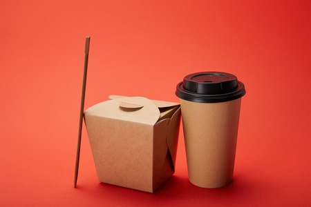 noodle box, paper cup of coffee with chopsticks on red, minimalistic conceptの写真素材
