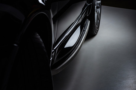 close up view luxury shining black automobile on dark backgroundの写真素材