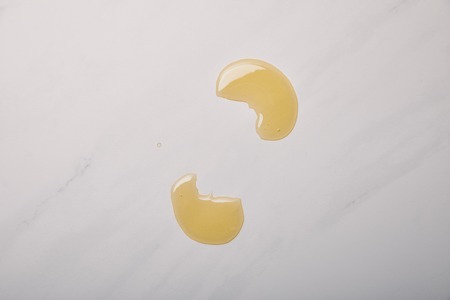 top view of spilled yellow soap on white marbleの写真素材