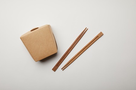 top view of arranged chopsticks and noodle box on white surface, minimalistic conceptの写真素材