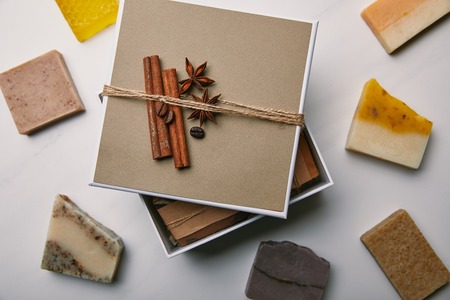 top view of decorated box with handmade soap on white marble surfaceの写真素材