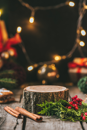 wooden stump with cinnamon sticks, fir tree and christmas light garlandの写真素材