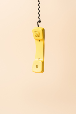 yellow vintage phone tube on beigeの写真素材