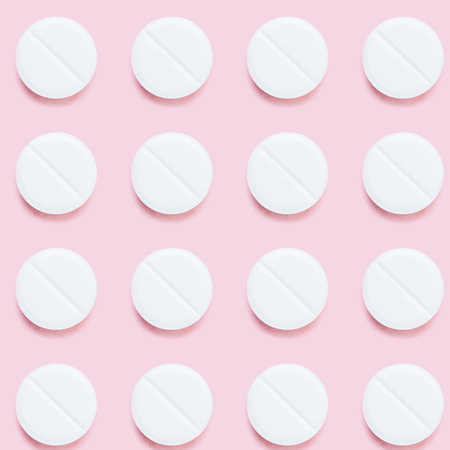 top view of pattern of medical pills on pink surfaceの写真素材