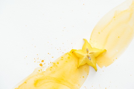 top view of star fruit on white surface with yellow watercolorの写真素材