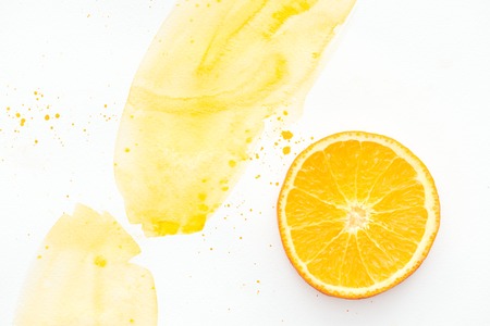 top view of yummy orange piece on white surface with yellow watercolorの写真素材