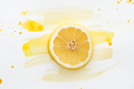 elevated view of lemon piece on white surface with yellow watercolorの写真素材