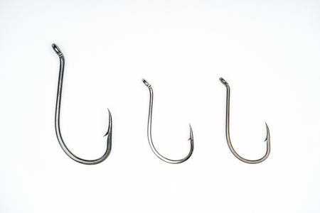 elevated view of three fishing hooks placed in row isolated on white