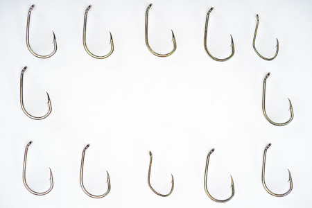 elevated view of arranged fishing hooks isolated on whiteの写真素材