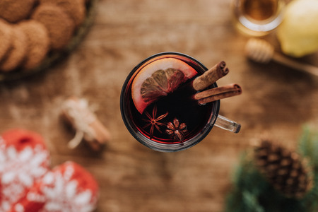 top view of mulled wine with cinnamon sticks and lemon in glass on wooden tabletop, christmas conceptの写真素材