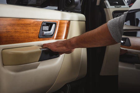 cropped shot of man closing car door while sitting in carの写真素材