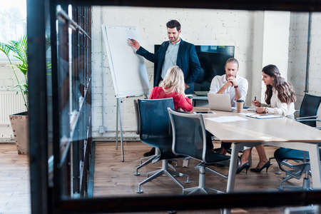 businessman pointing at blank white board during meeting in officeの写真素材