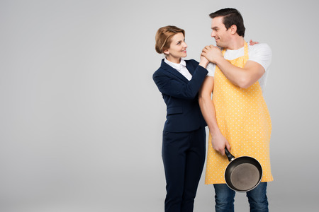 businesswoman and male householder hugging together, feminism concept, isolated on greyの写真素材
