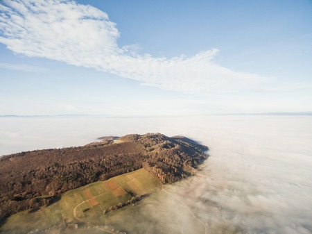 aerial view of beautiful forest and green fields in fog, Germanyの写真素材