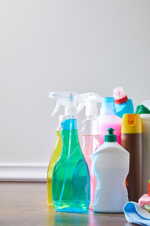 colored domestic supplies for spring cleaning on wooden floorの写真素材