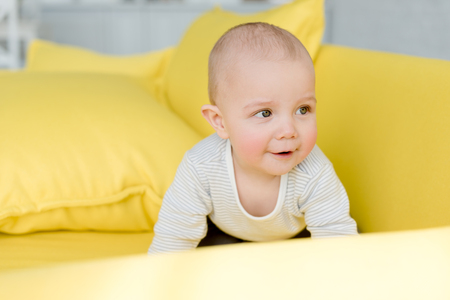 adorable little baby boy on yellow sofa