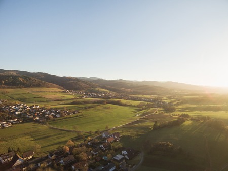 aerial view of rooftops, houses and beautiful green hills with trees at sunlight, Germanyの写真素材