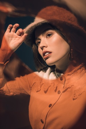 portrait of fashionable young woman in hat looking awayの写真素材