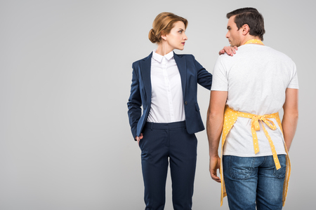 businesswoman and male householder standing together, feminism concept, isolated on greyの写真素材