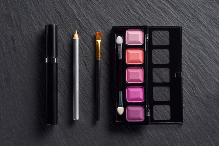 Make up set with eye shadows, pencil and mascara on dark slate backgroundの写真素材
