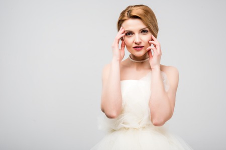 portrait of attractive tender bride in white wedding dress, isolated on greyの写真素材