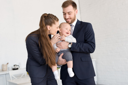 happy business couple holding son at homeの写真素材