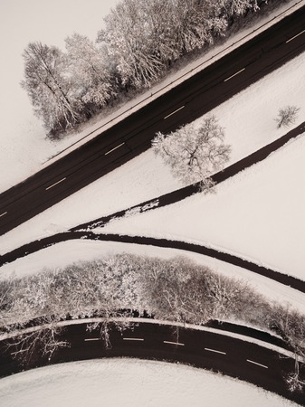aerial view of empty asphalt road and snow-covered trees at winter, Germany