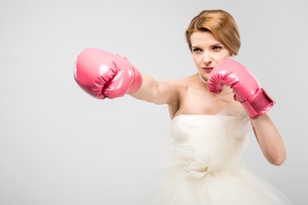 strong bride in wedding dress and boxing gloves, isolated on grey, feminism conceptの写真素材