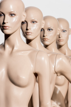 close-up view of naked bald dummies in a row on whiteの写真素材