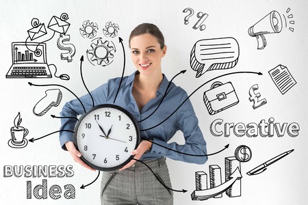 Smiling businesswoman holding wall clock in hands on white with creative business idea inscription and hand-drawn iconsの写真素材