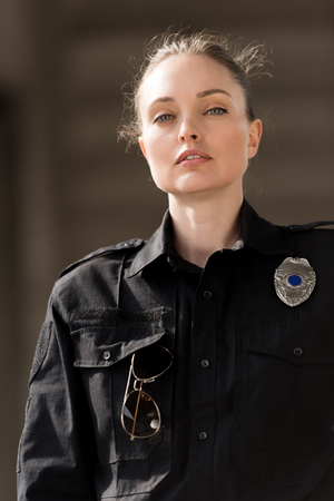 attractive female police officer in uniform looking at camera