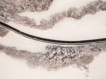 aerial view of asphalt road and snow-covered trees at winter, Germanyの写真素材