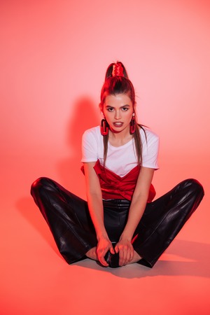 toned picture of pensive young woman in stylish clothing looking at cameraの写真素材